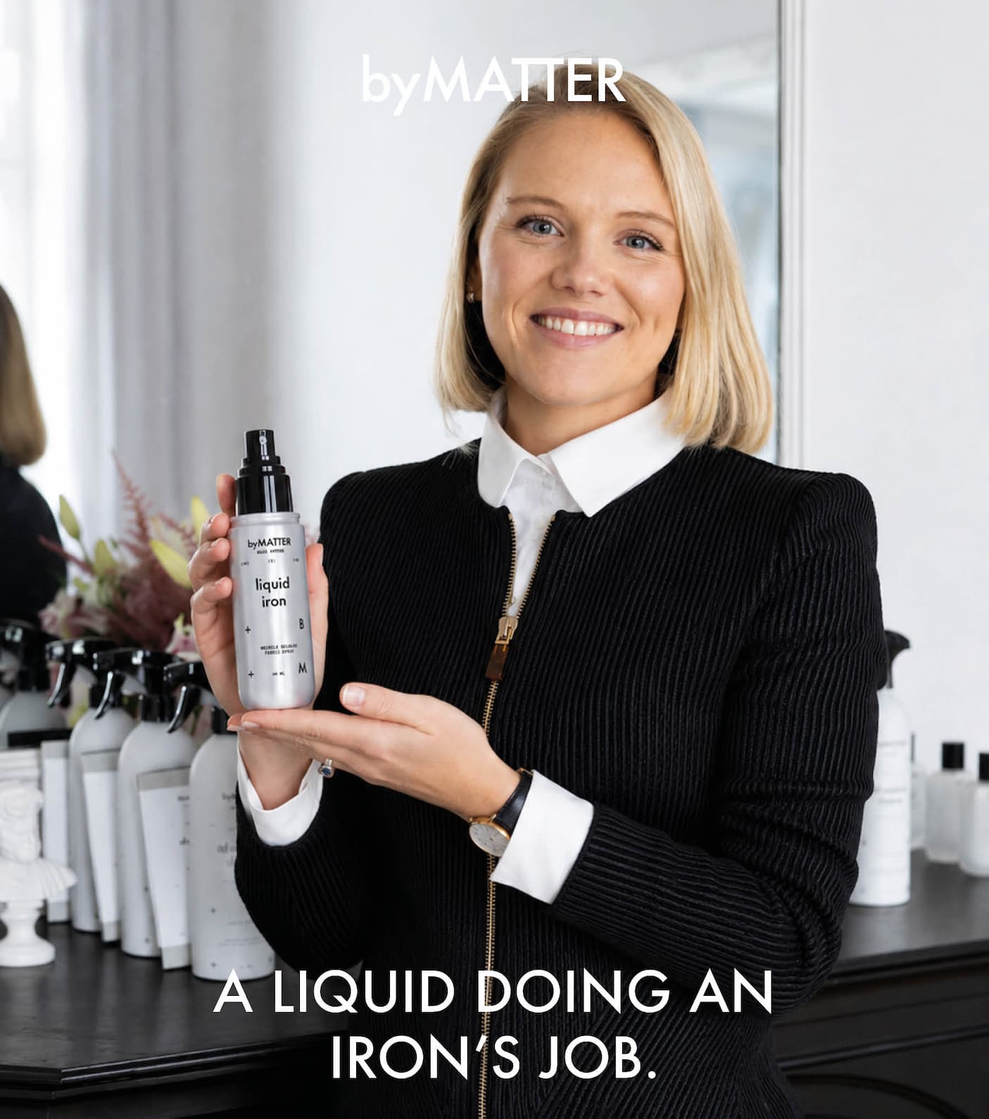 byMATTER Liquid Iron bottle in Hollys hands. A liquid doing an iron's job.