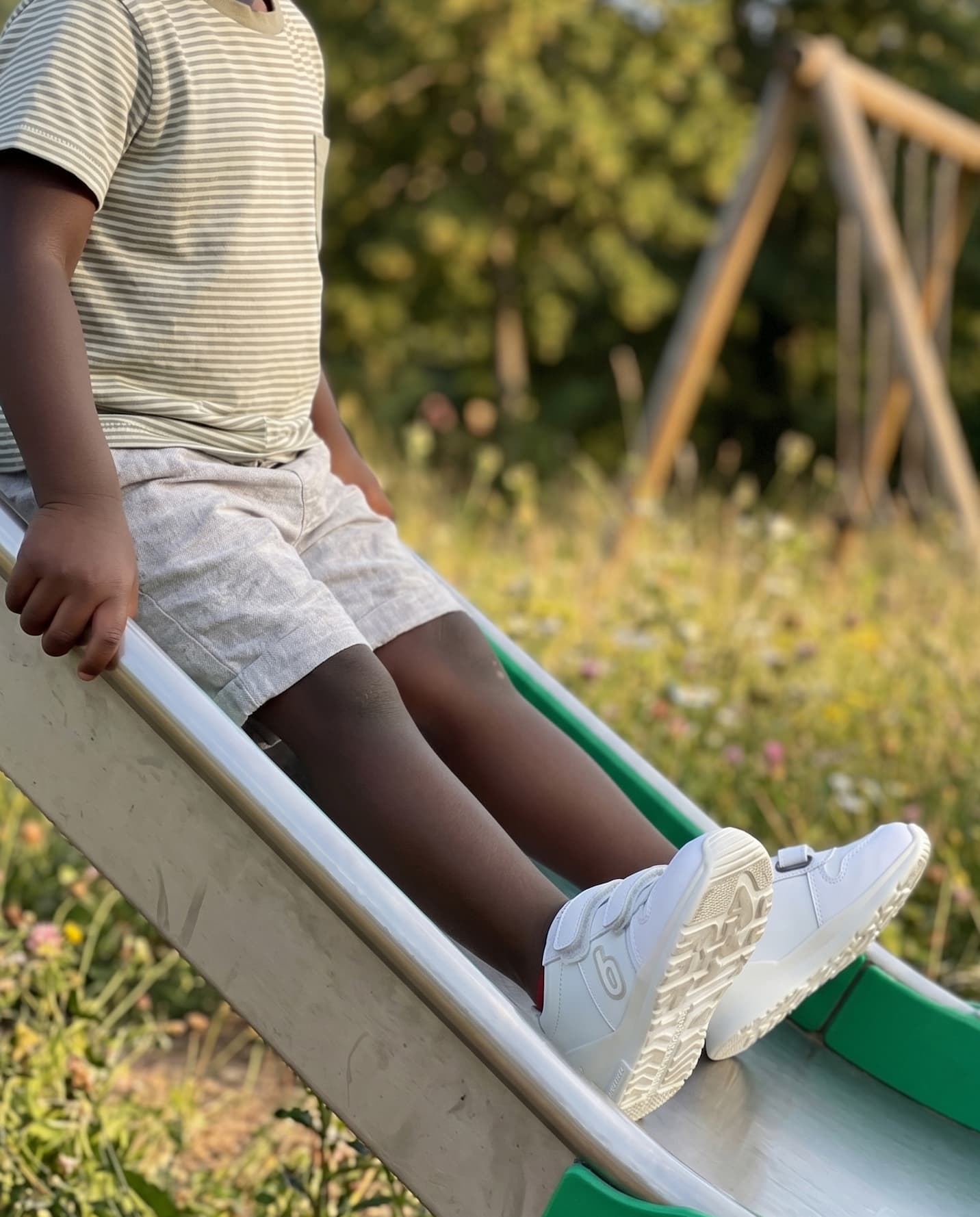 Niño con zapatillas blancas en un parque