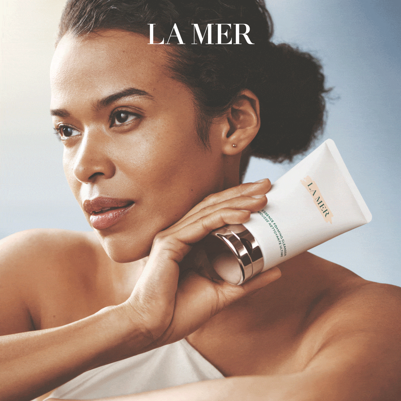 Animation displays a close-up face of a woman applying La Mer cleanser.