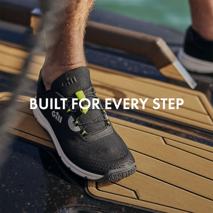 Black trainers being worn on a powerboat