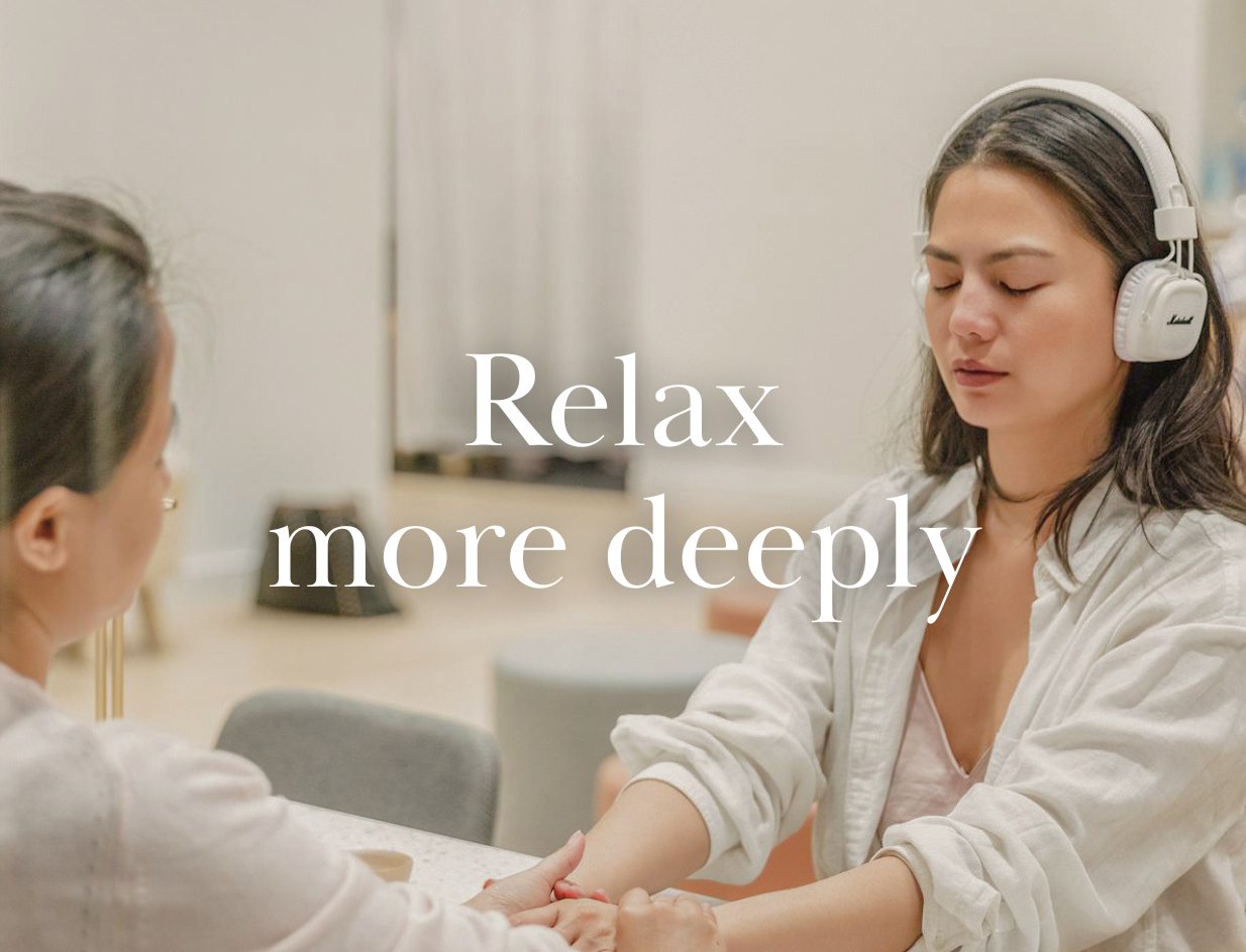 Person wearing headphones while enjoying a spa pedicure.
