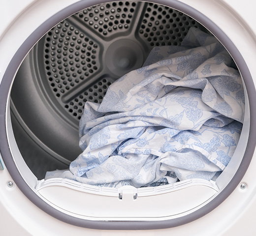 A dryer filled with bedsheets