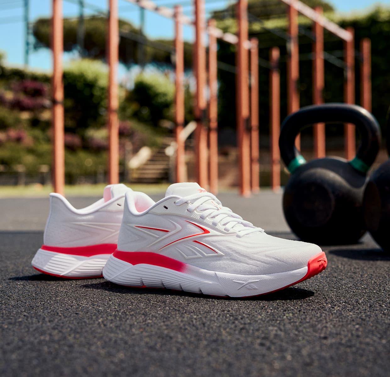 Collage featuring Nano Gym 2.0 training shoes in white and coral. The images show the shoes on the ground beside kettlebells, during strength training, and in outdoor workouts.