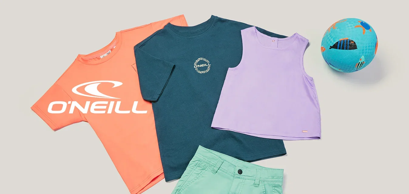 Drie kleurrijke T-shirts, groene shorts en een blauwe voetbal, gerangschikt op een effen lichte achtergrond.
