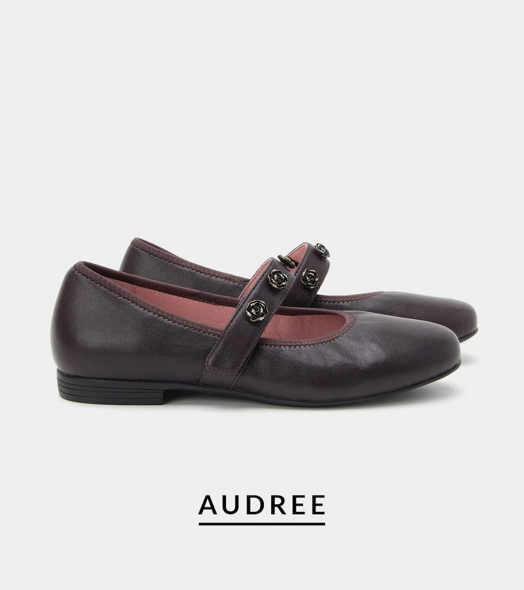 Side view of Alegria Audree leather ballet flat in deep Midnight Plum, with an adjustable hook-and-loop strap adorned with floral rosette hardware. 