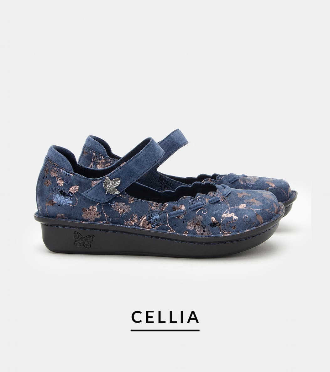 Side view of the Alegria Cellia Mary Jane shoe in Lumen Navy blue suede with metallic floral detailing, scalloped trim, an adjustable hook-and-loop strap with leaf ornament, and a black comfort mini outsole.