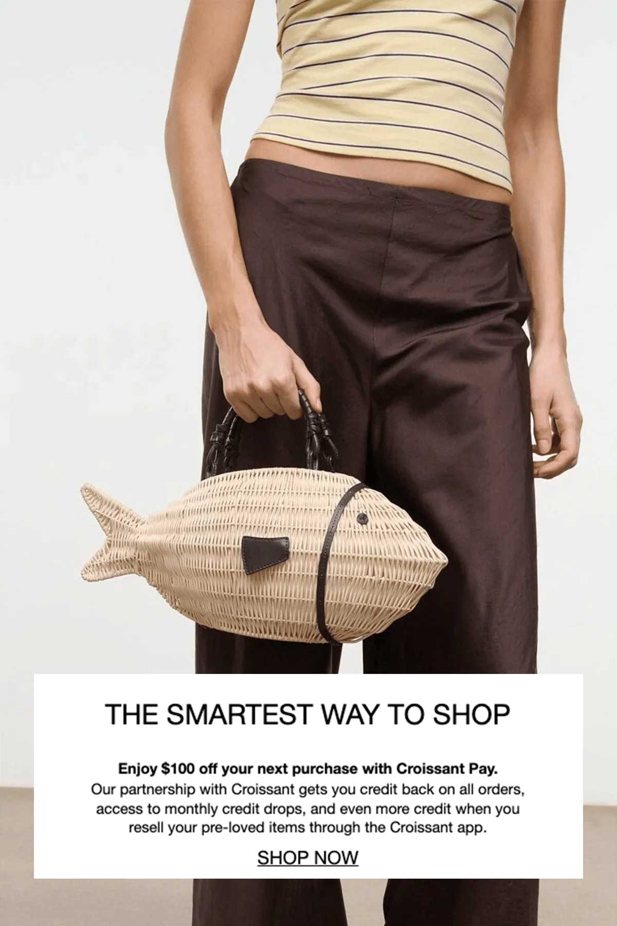 Model carrying the Staud Cleo woven fish bag