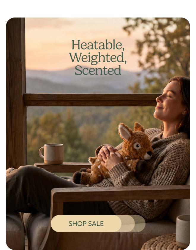A woman hugging Laying Down Deer Warmies. Shop Sale.