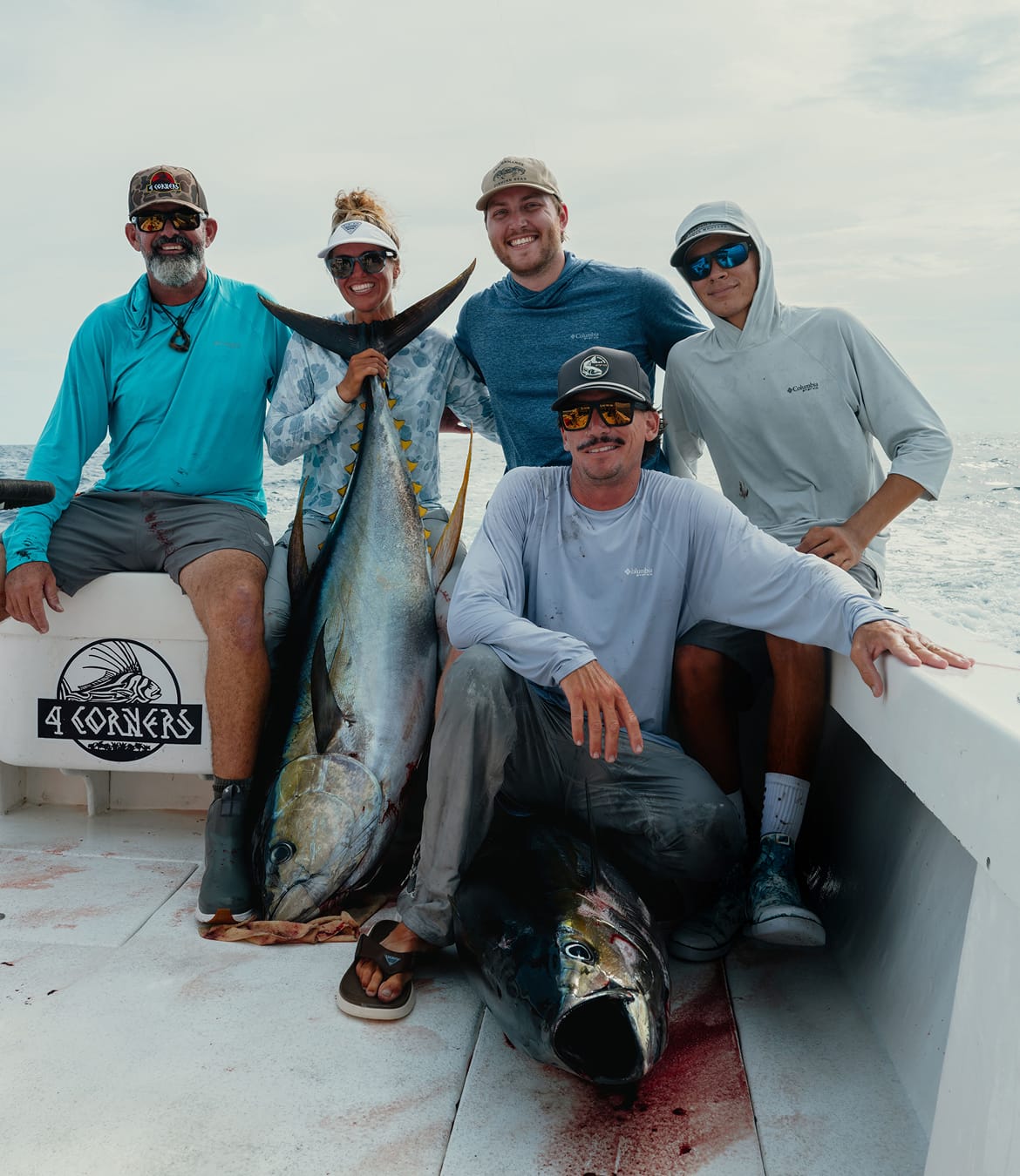 Anglers on a boat with two large fish.