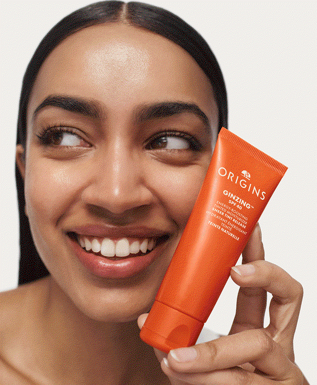 Close-up of a woman applying the new GinZing™ SPF 40 Tinted Moisturizer to her face.