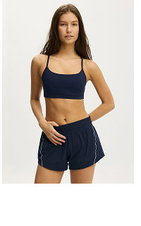 Woman wearing navy sports bra and matching shorts