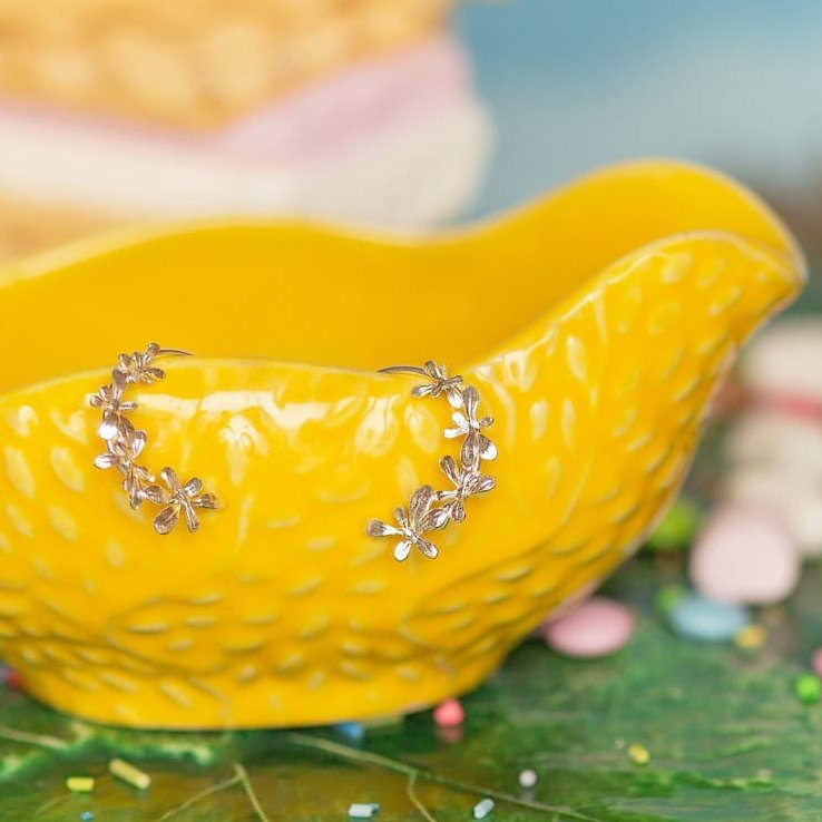 Sprouting Rosette Hoop Earrings on yellow ceramic jug.
