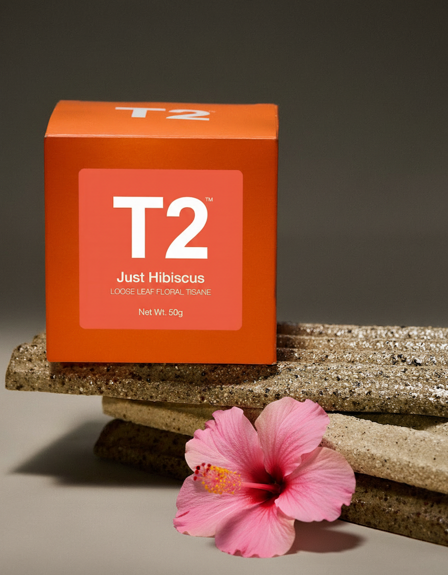 An orange T2 tea box with "Just Hibiscus" and a pink hibiscus flower