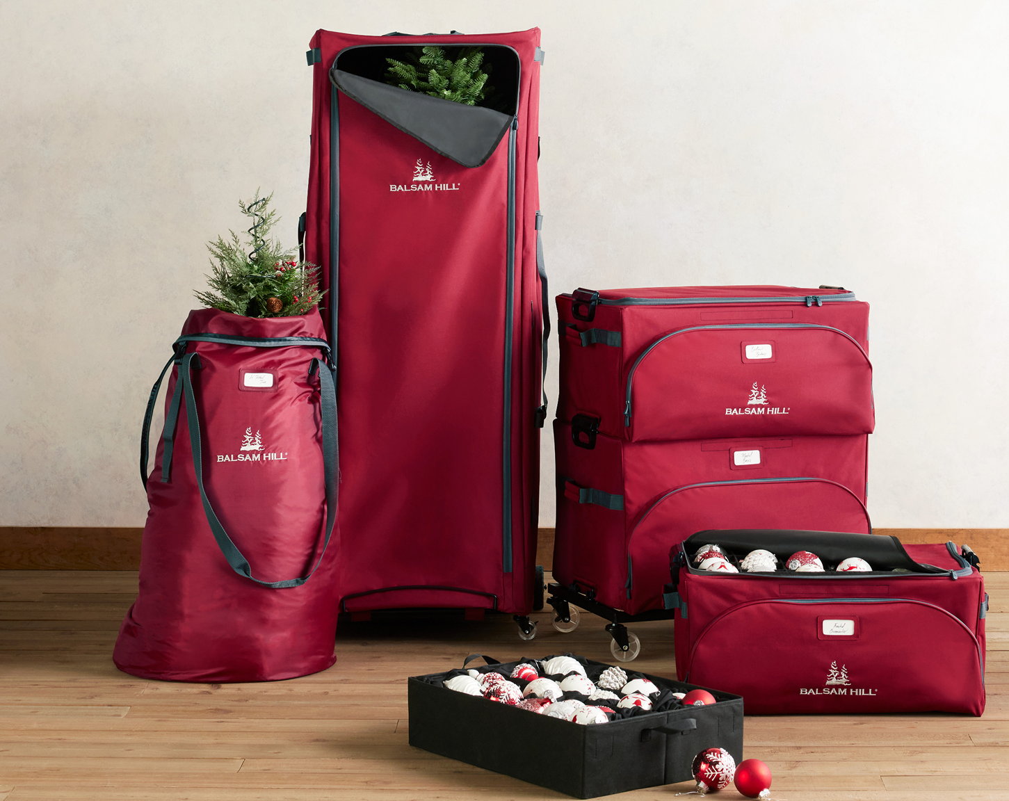 Red Christmas storage bags and boxes for trees, wreaths, garlands, and ornaments, displayed with holiday décor.