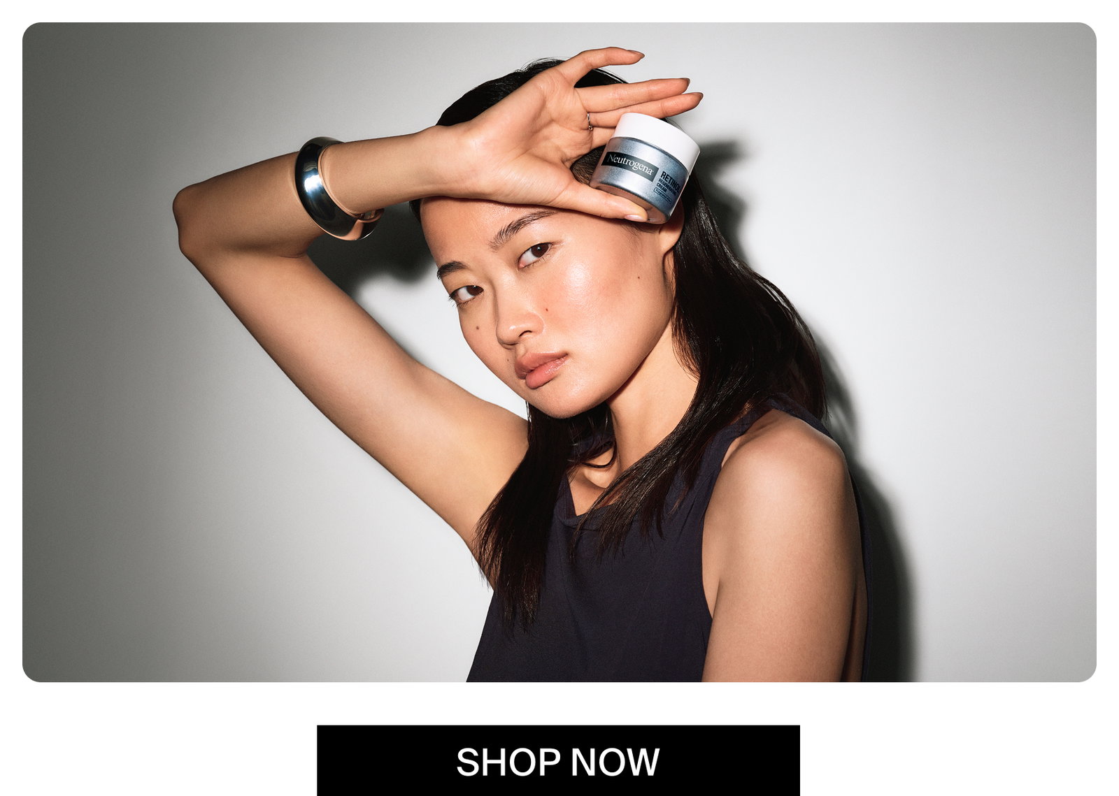 Woman with clear healthy skin holding up a jar of Neutrogena® Rapid Wrinkle Repair® Retinol Regenerating Cream Fragrance Free