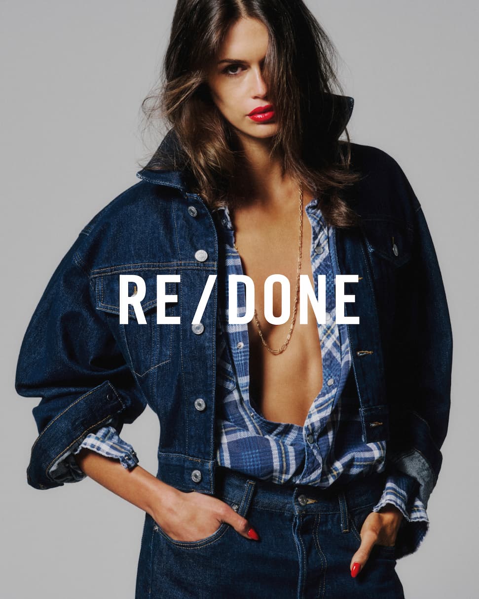 an image of a woman in a tank top and jeans posing for a picture