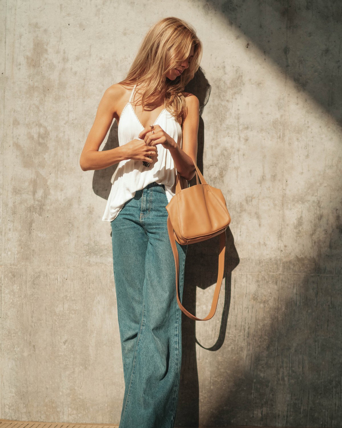 The Little Times Tote worn crossbody in warm daylight.