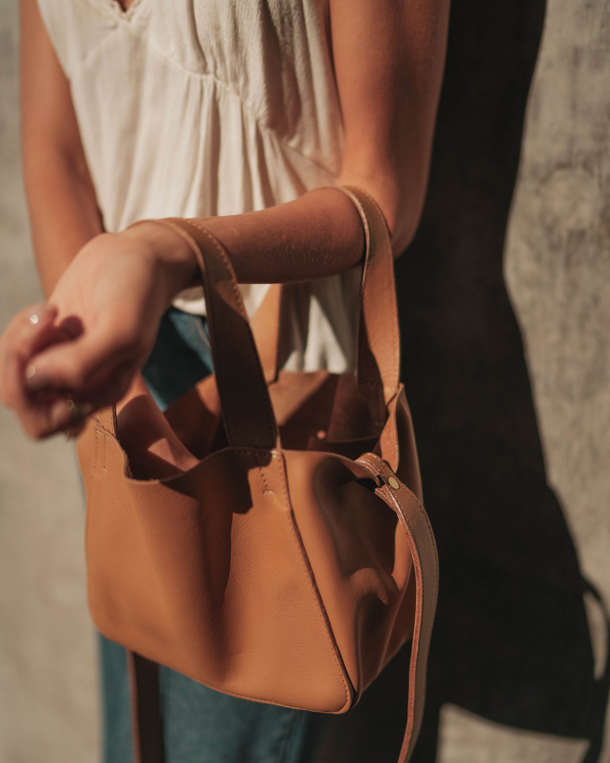 The Little Times Tote held by the top handles.