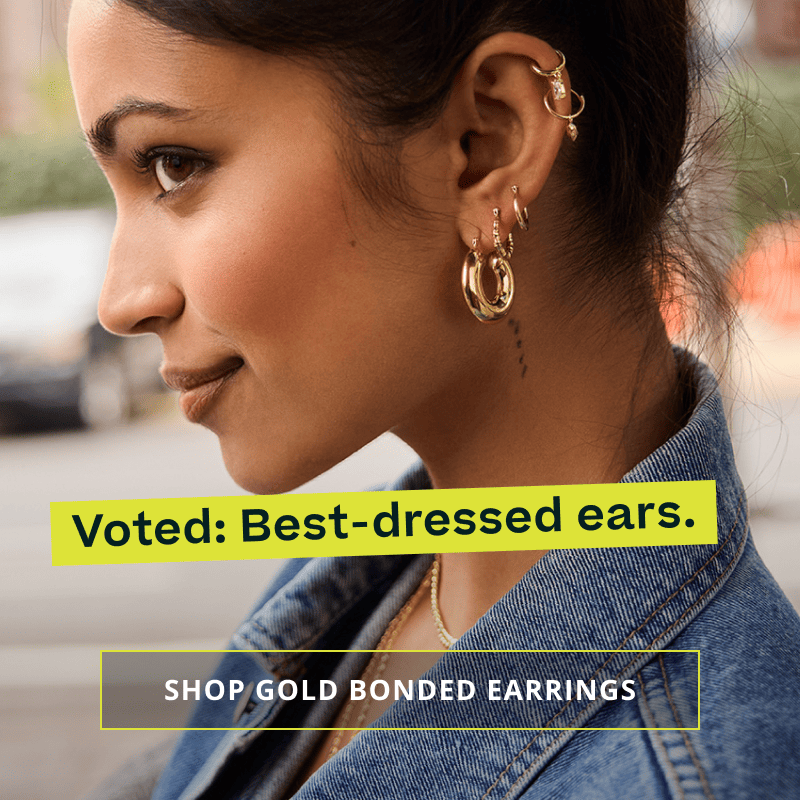 Model with unique gold ear stack with dangling elements. Voted: best-dressed ears. Click here to shop gold bonded earrings