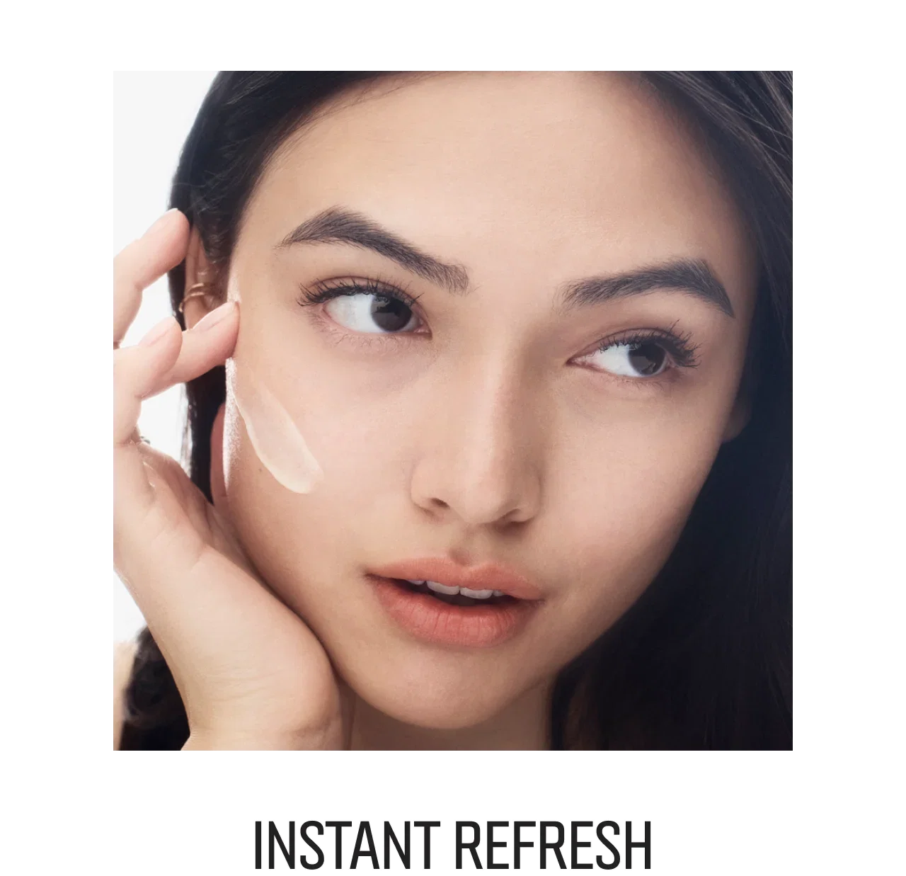 Close-up of a woman applying the new Vitamin Enriched Face Base+ to her cheek, with title 'Instant Refresh' below.