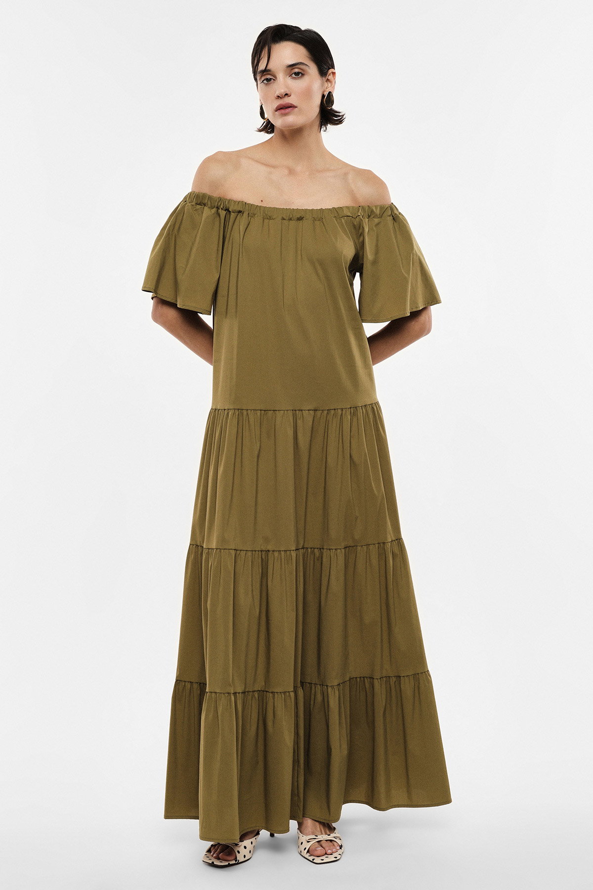 Olive off-the-shoulder tiered maxi dress on model, short flutter sleeves and ruffled tiers, styled with flat sandals
