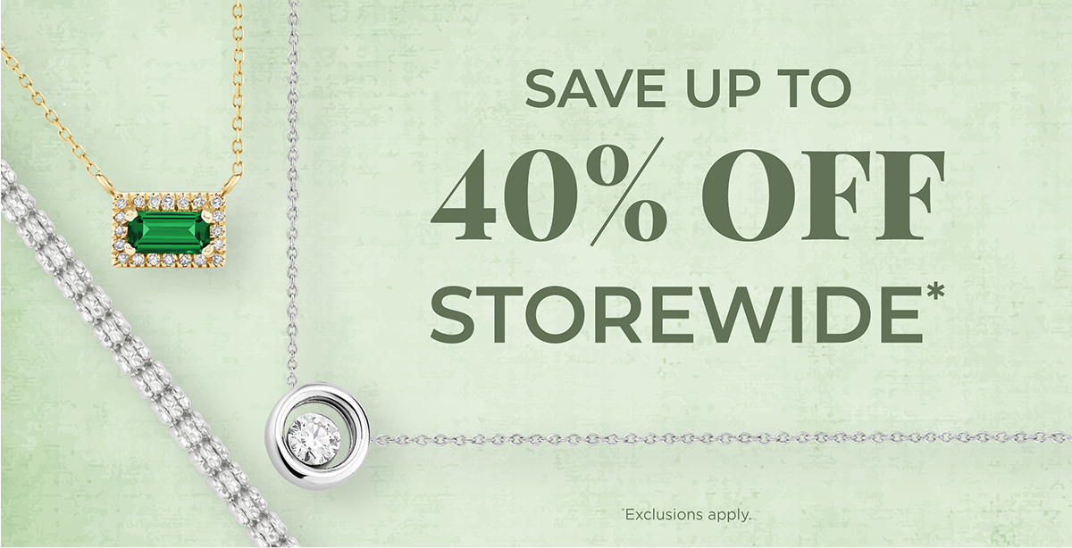 Promo banner reading 'Save Up To 40% Off Storewide' with an asterisk noting exclusions apply, set against a sage green textured background. Features a gold necklace with an emerald baguette pendant surrounded by diamonds, a diamond tennis bracelet, and a white gold necklace with a solitaire diamond pendant.