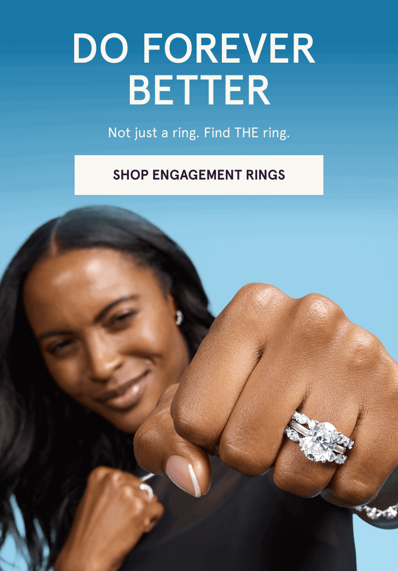 Focus on model’s oval-centered diamond ring nestled between eternity bands. Find THE ring. Click here to shop engagement rings