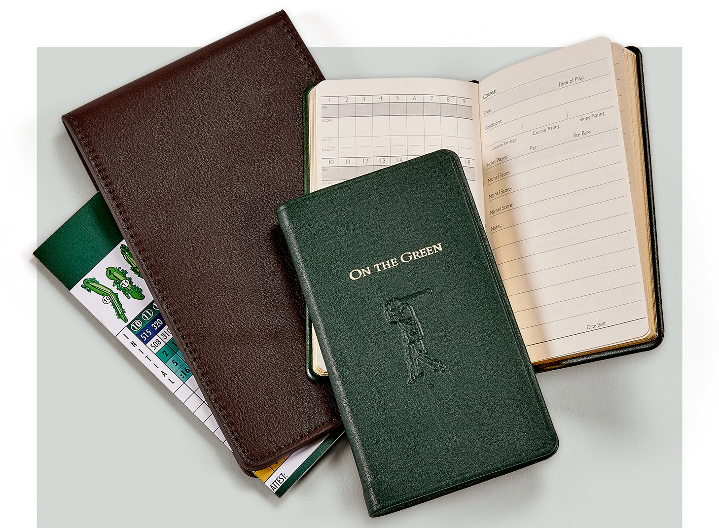 A leather-bound golf scorebook and golf scorecard cover.