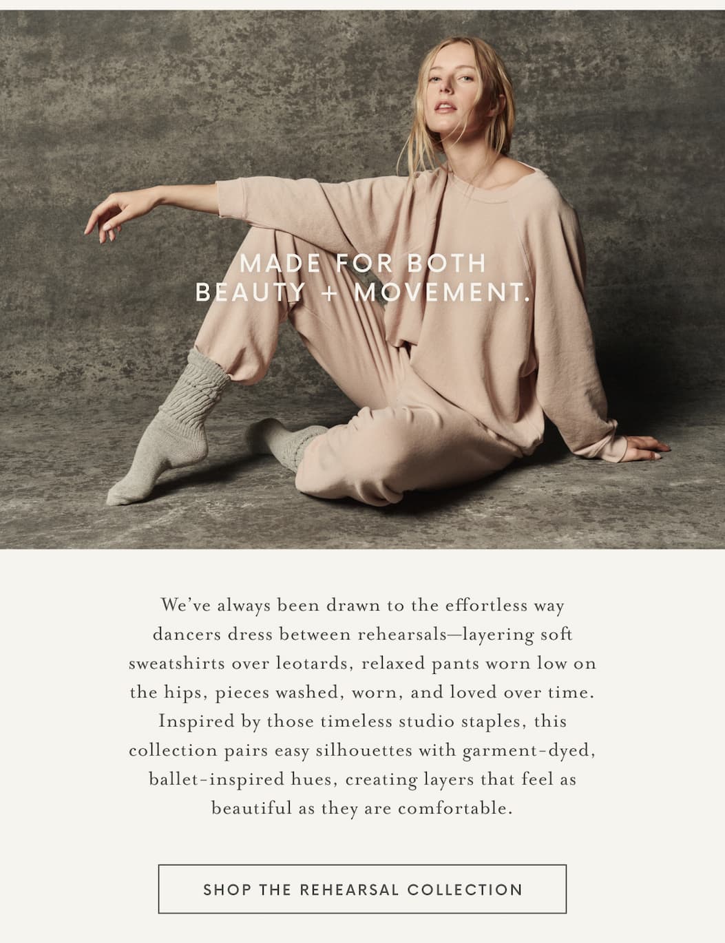Model seated on a studio floor wearing a blush pink oversized sweatshirt and matching relaxed sweatpants with scrunched knit socks. White overlay text reads, “Made for Both Beauty + Movement.” Below, editorial copy introduces the Rehearsal Collection, inspired by dancers' off-duty style, with a button that reads “Shop the Rehearsal Collection.”