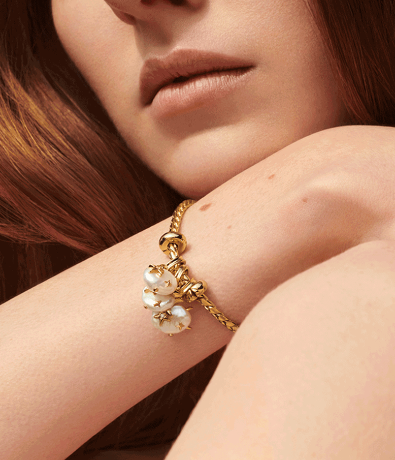 Close up of a model wearing Pandora Wonders charms on a bracelet