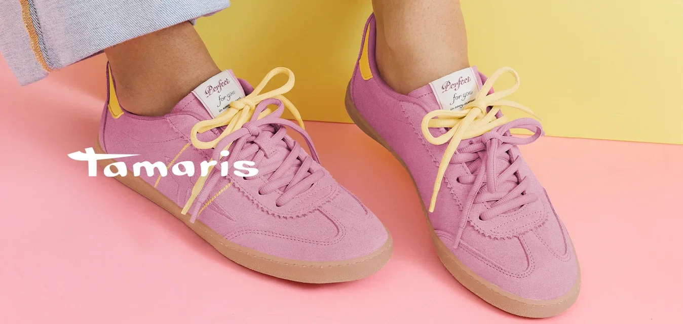 Personne portant des baskets roses avec des lacets jaunes et un jean bleu clair assise sur une forme géométrique jaune sur un sol rose.