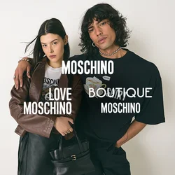 Joven con cabello rizado, camiseta gráfica negra, con el brazo alrededor de una mujer que lleva una chaqueta marrón, falda negra y sostiene un bolso negro.