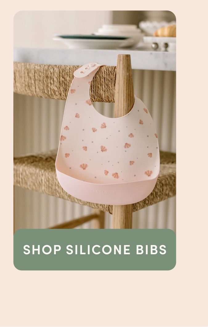 pink silicone bib printed with seashells and hung over a bar chair