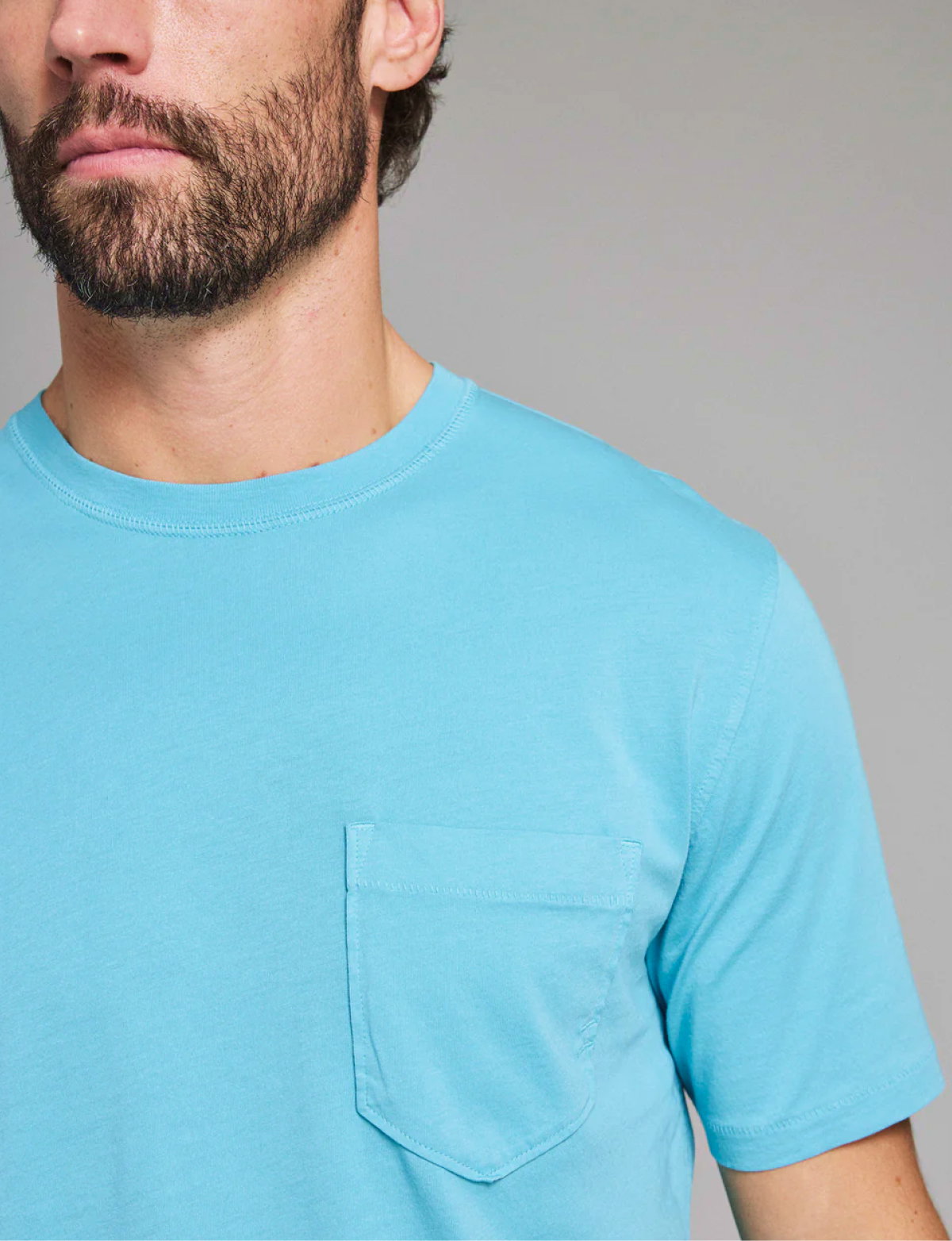 Model wears a t-shirt in a bright blue.