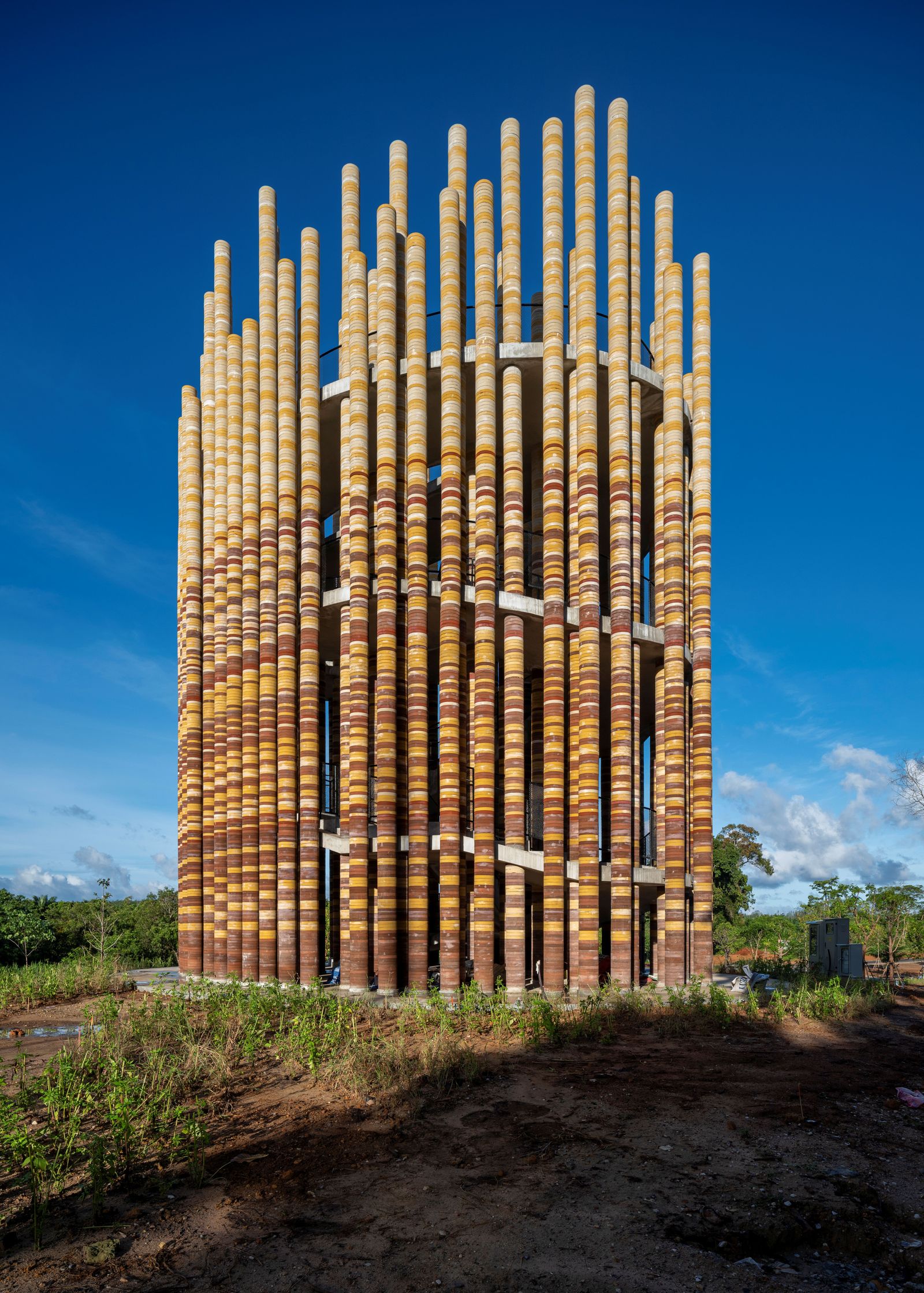 Architectural installation made of tall poles, each crafted from Elephant dung