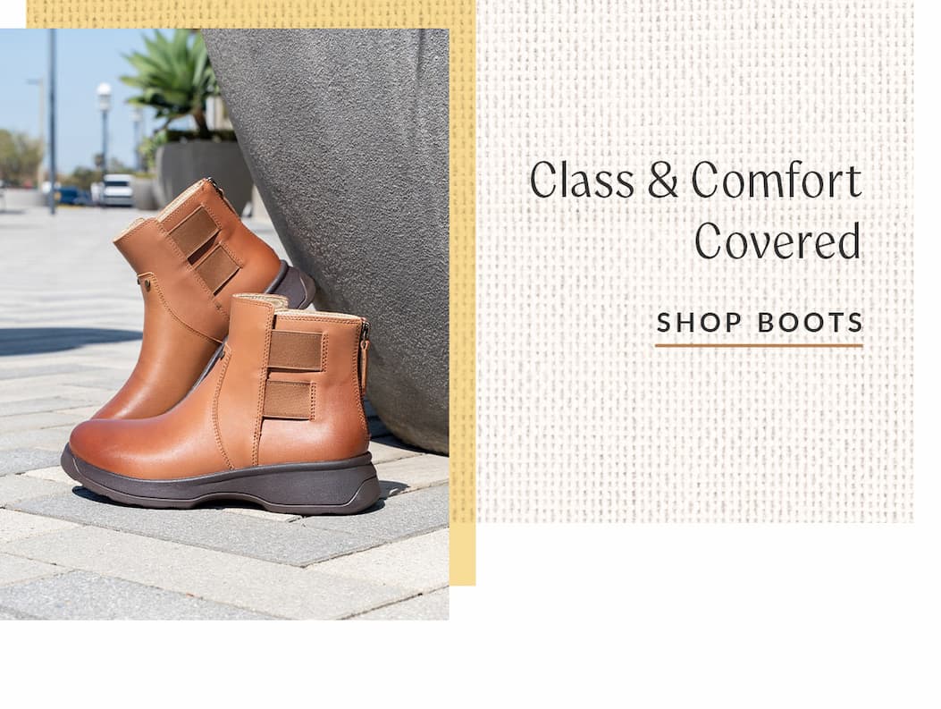 A pair of Alegria Jordan Smoked Tan leather ankle boots with side zippers displayed outdoors on a paved surface next to a large planter. Text reads: “Class & Comfort Covered. Shop Boots.”.
