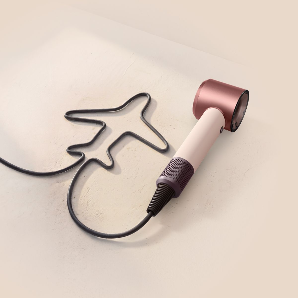 Dyson Supersonic Travel hair dryer with the cable shaped to resemble an aeroplane.