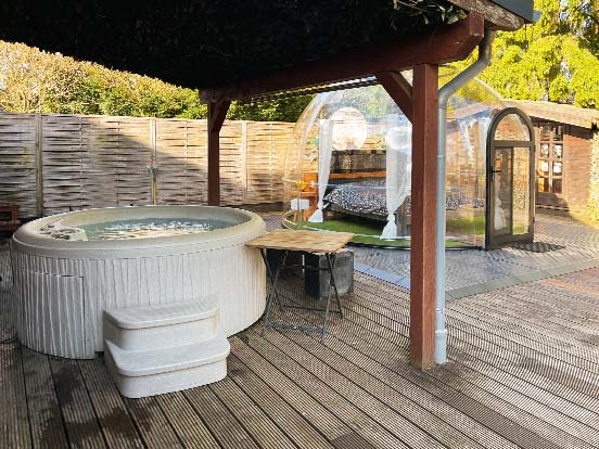 Ein Whirlpool steht neben einem Bubble Hotel.