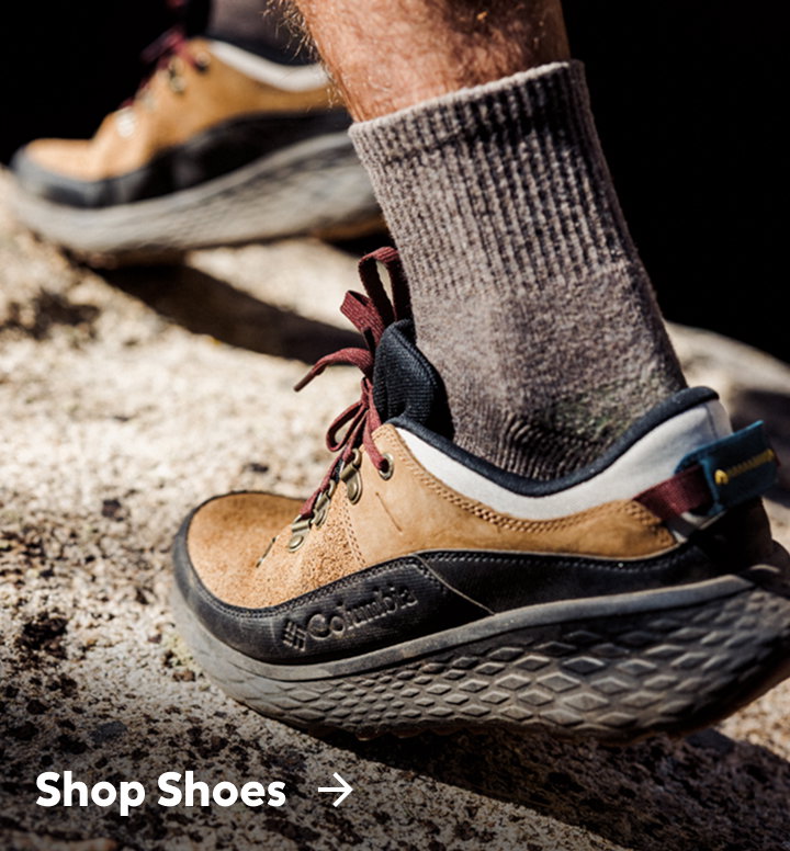 Close-up of a man's brown and black hiking shoes with text: Shop Shoes