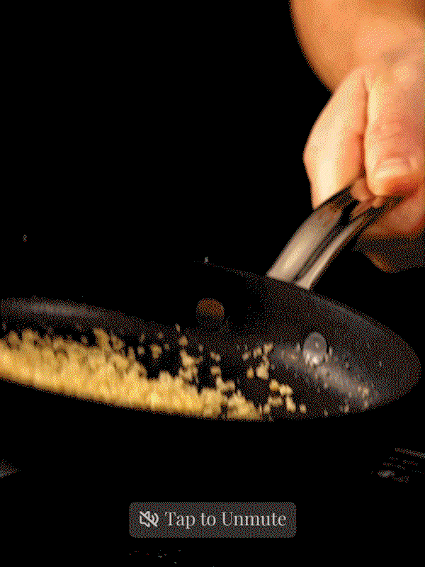 GIF: Chef Chad Montano cooking using Hestan TITUM Fusion skillet. Button that reads Tap to Unmute.