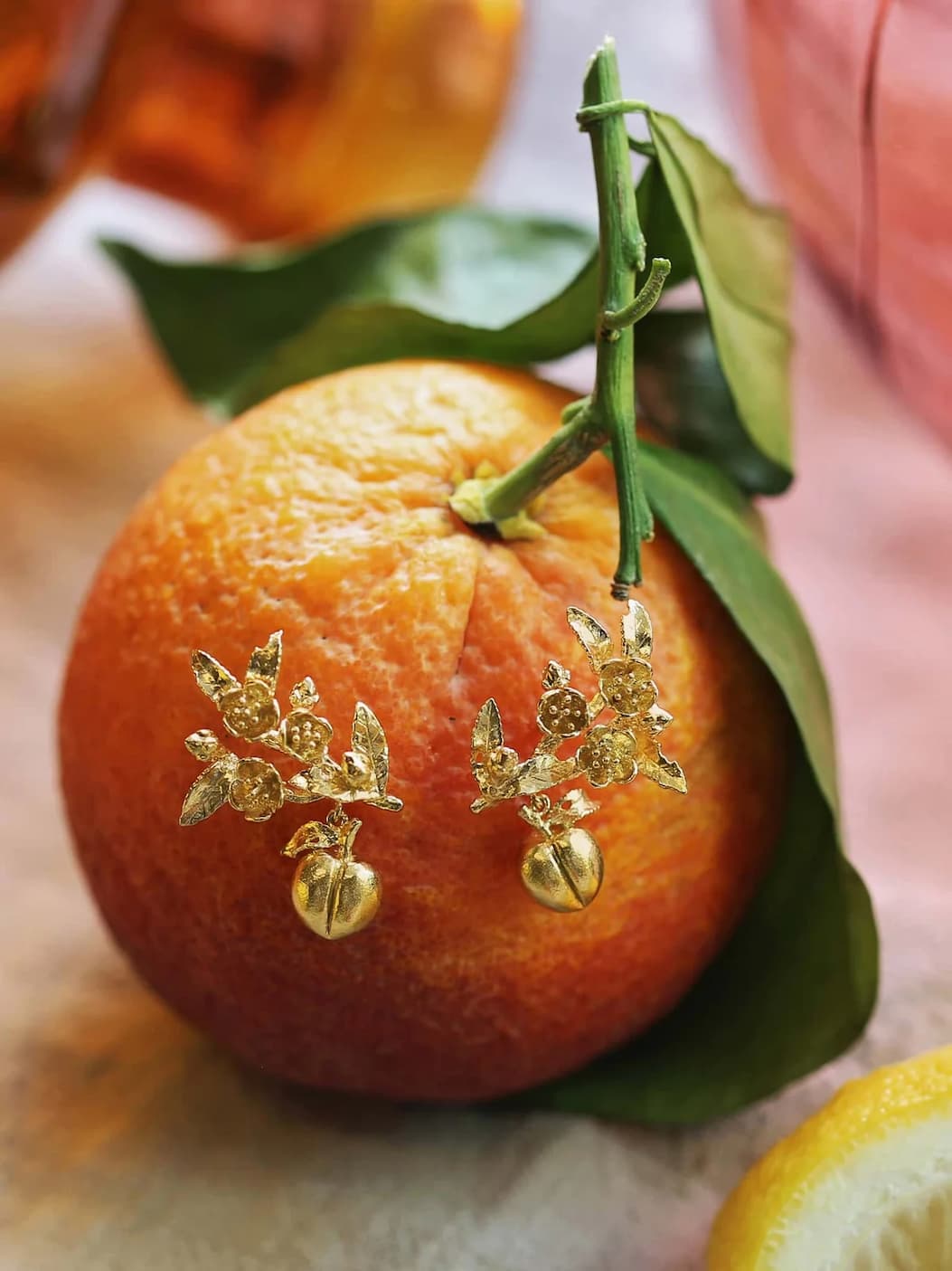 Fresh orange with gold Peach Blossom Branch Climber Earrings with Hanging Peaches jewellery, styled for summer.
