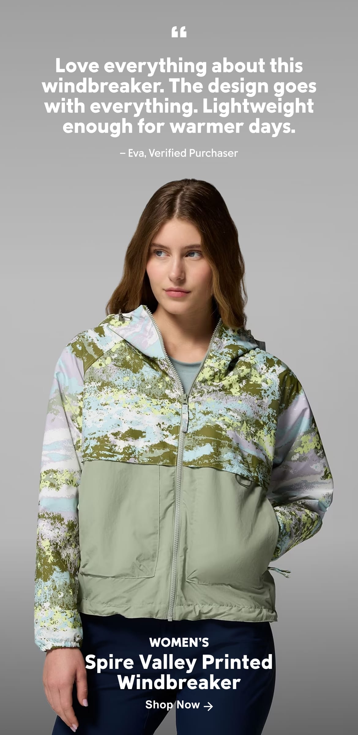A woman wearing a multi-colored jacket with text: 