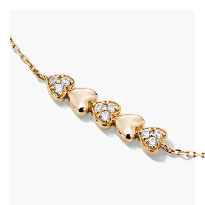 Yellow gold bracelet with solid gold hearts and gold hearts with stones. 