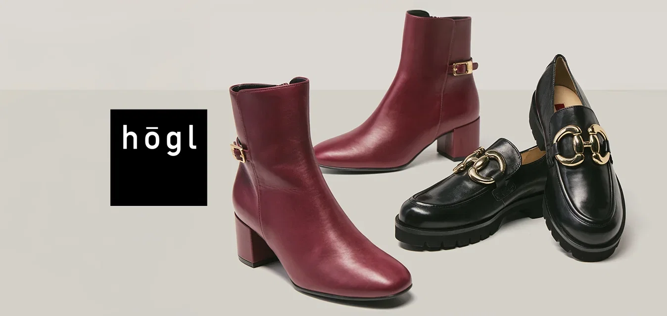 Un par de botas de tobillo burdeos con tacones de bloque y un par de mocasines de cuero negro con detalles de hebilla dorada sobre un fondo neutro.