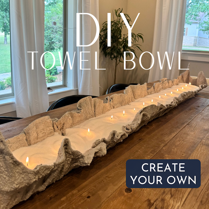 DIY towel bowl centerpiece filled with white pearled candle wax and multiple lit wicks, displayed on a rustic wooden dining table. Create your own custom candle centerpiece with Foton Pearled Candles.