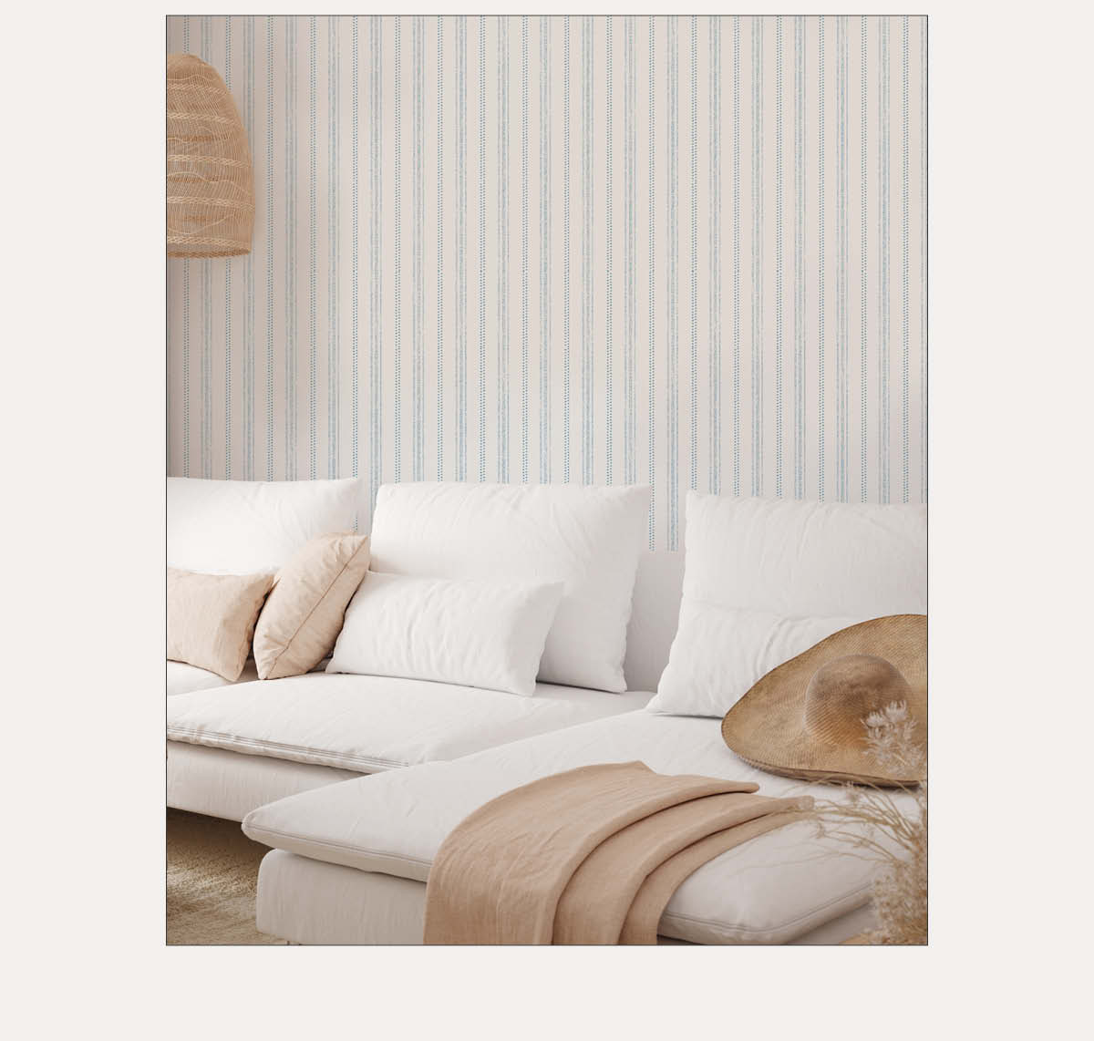 Image of Tempaper's Nautical Stripe wallpaper on a wall behind a white couch. 