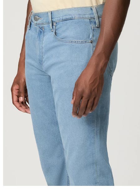 Detail shot of a man wearing blue denim jeans.