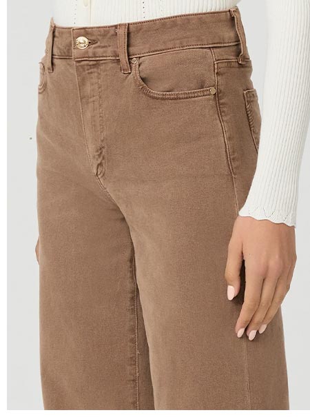 Detail shot of a woman wearing brown denim jeans.