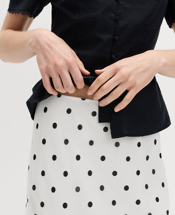 Woman wearing an Ivory Mix Polka Dot Knee Length Slip Skirt