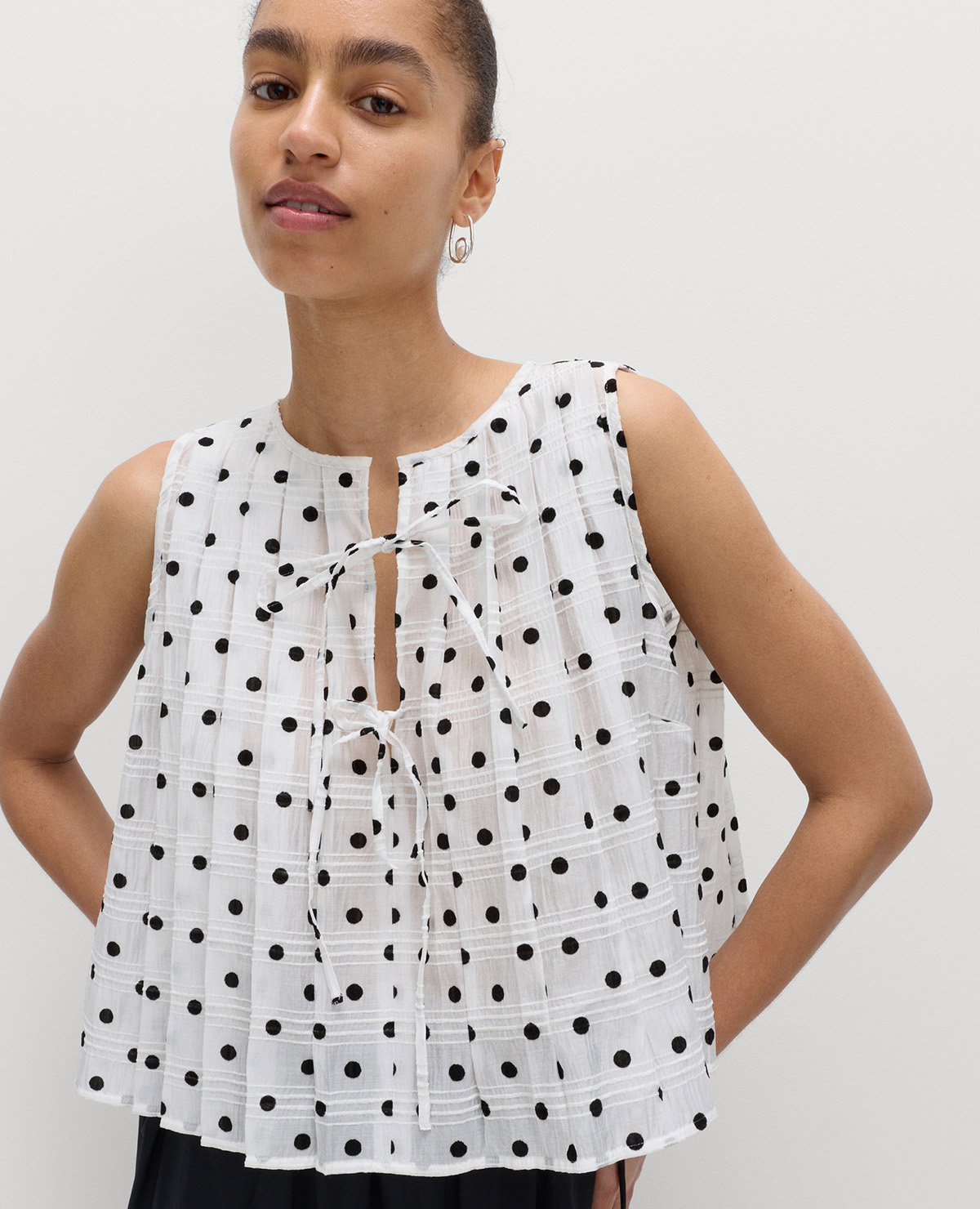 Woman wearing a white Lyocell Blend Polka Dot Tie Front Top
